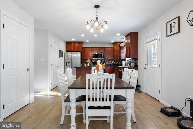 dining room featuring a notable chandelier and light hardwood / wood-style floors