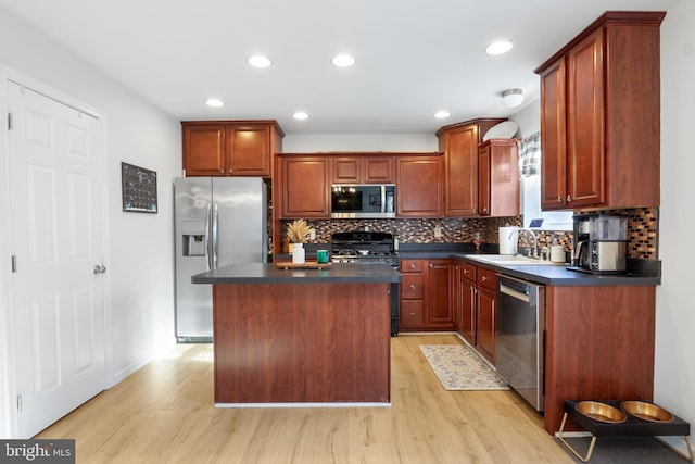 kitchen featuring backsplash, a kitchen island, sink, light hardwood / wood-style flooring, and stainless steel appliances