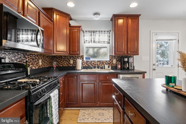 kitchen with dishwasher, tasteful backsplash, light hardwood / wood-style floors, sink, and black gas range