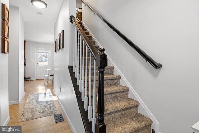 stairs featuring hardwood / wood-style floors