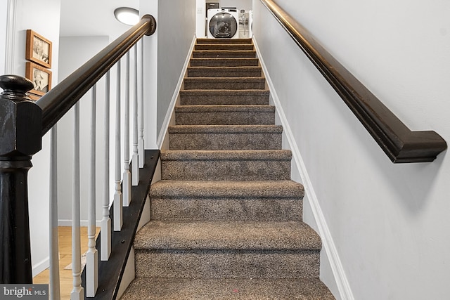 stairs with washer / dryer and hardwood / wood-style floors