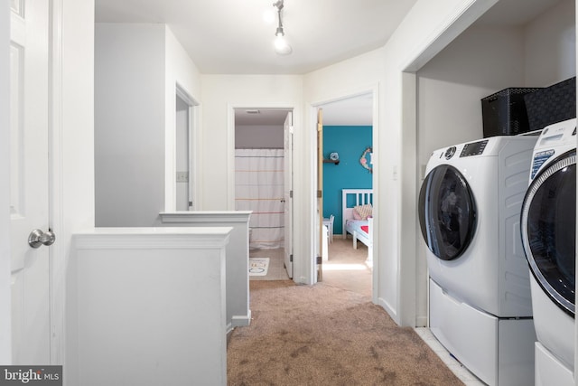 washroom featuring washer and clothes dryer and light colored carpet