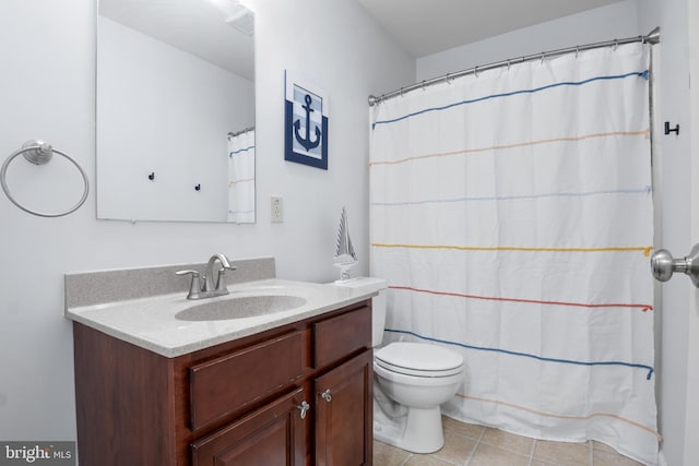 bathroom with toilet, vanity, and tile patterned flooring