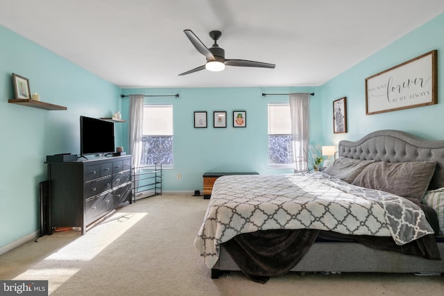 bedroom featuring ceiling fan, light colored carpet, and multiple windows