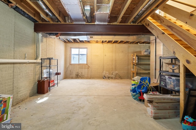 basement featuring brick wall