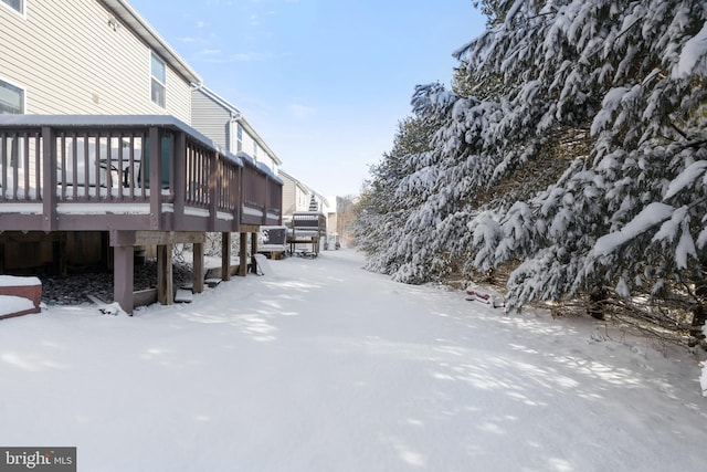 yard covered in snow with a deck