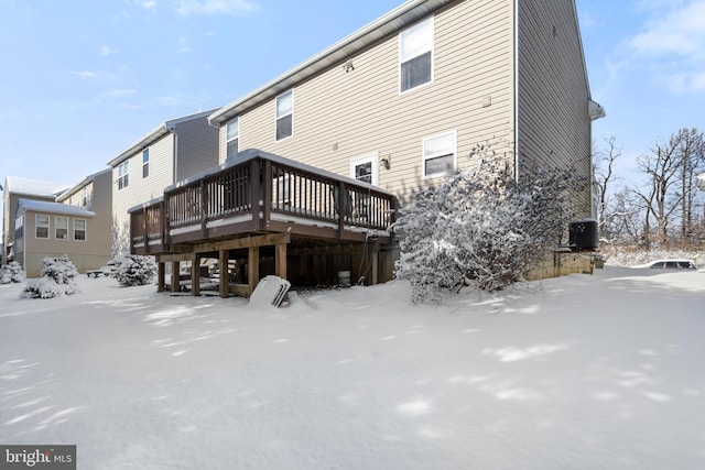 snow covered property with a deck and central AC unit