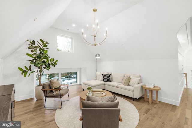 living room with light hardwood / wood-style flooring, lofted ceiling, and a notable chandelier