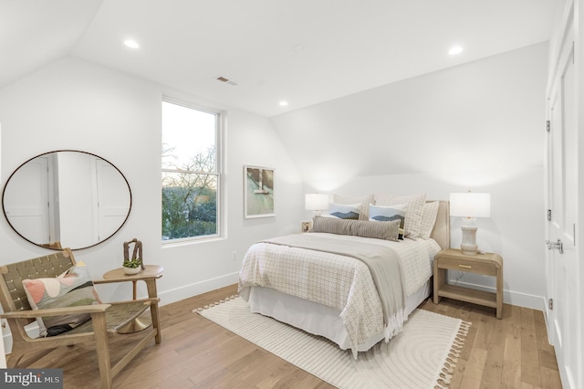 bedroom with vaulted ceiling and light hardwood / wood-style flooring