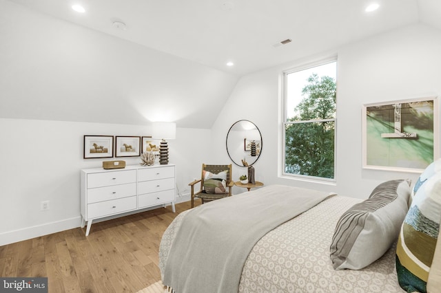 bedroom featuring lofted ceiling and light wood-type flooring