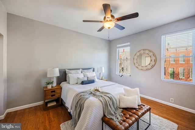 bedroom with dark hardwood / wood-style floors and ceiling fan