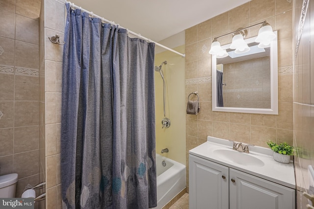 full bathroom with tile walls, vanity, toilet, tile patterned floors, and shower / bath combo with shower curtain