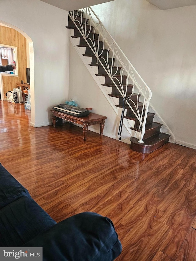 stairs with wood-type flooring and wooden walls