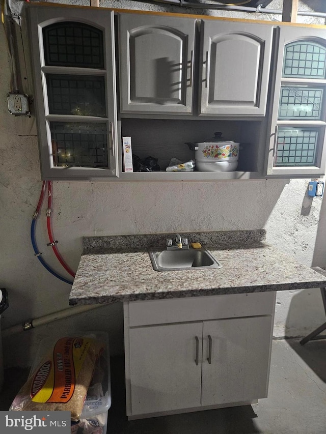 interior space with white cabinetry and sink