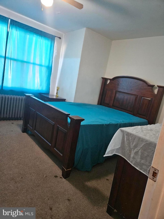 bedroom with radiator heating unit, carpet floors, and ceiling fan