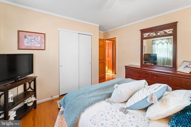 bedroom with light hardwood / wood-style floors, a closet, ceiling fan, and ornamental molding