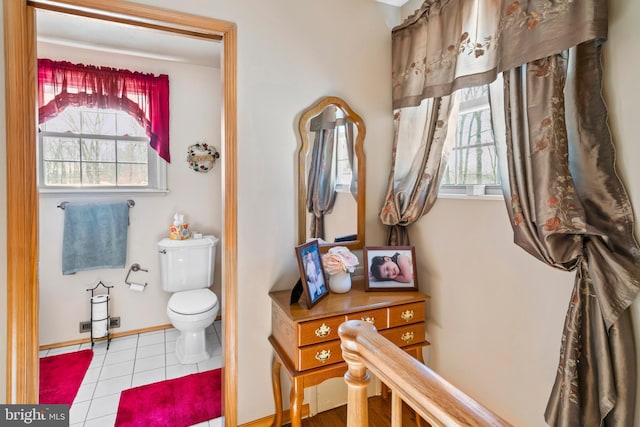 bathroom with toilet, plenty of natural light, and tile patterned flooring