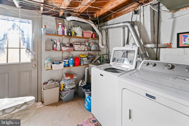 clothes washing area with light tile patterned floors and washing machine and clothes dryer