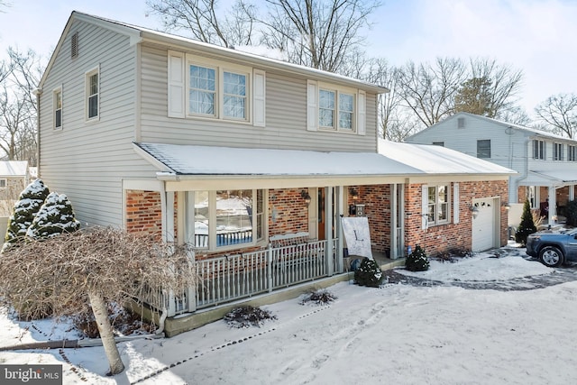 view of property featuring covered porch and a garage