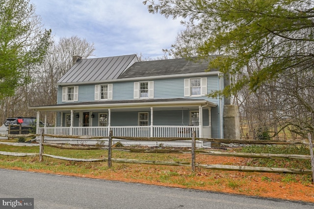 farmhouse inspired home featuring covered porch and a fenced front yard