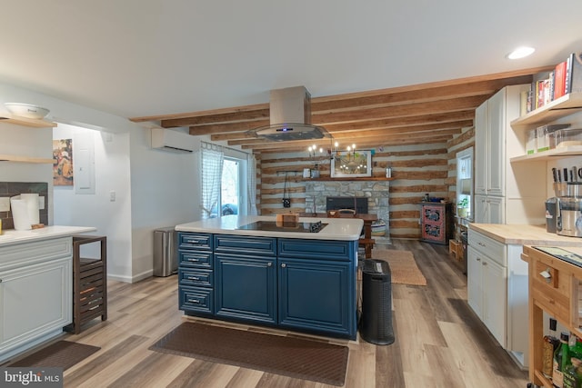 kitchen featuring beam ceiling, island exhaust hood, blue cabinetry, light countertops, and an AC wall unit