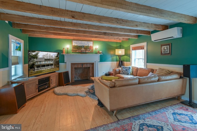 living room with wooden ceiling, light wood-style floors, a fireplace, beam ceiling, and a wall mounted AC