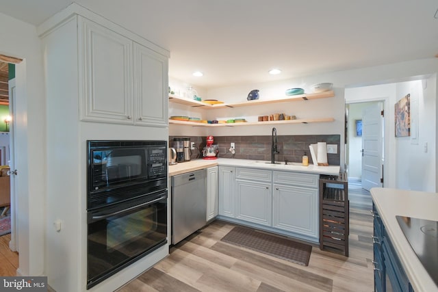 kitchen with black appliances, tasteful backsplash, open shelves, and light countertops