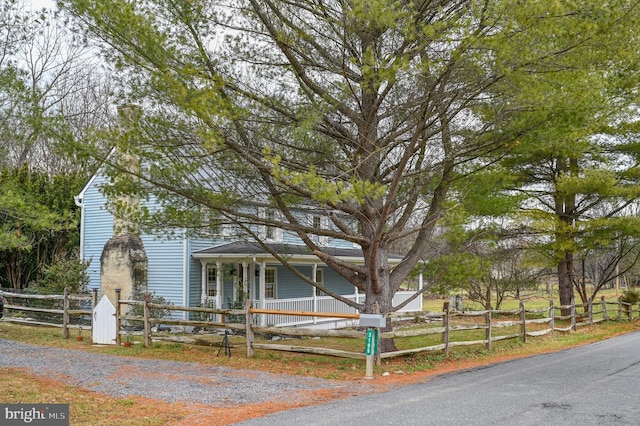 view of front facade with a porch and a fenced front yard