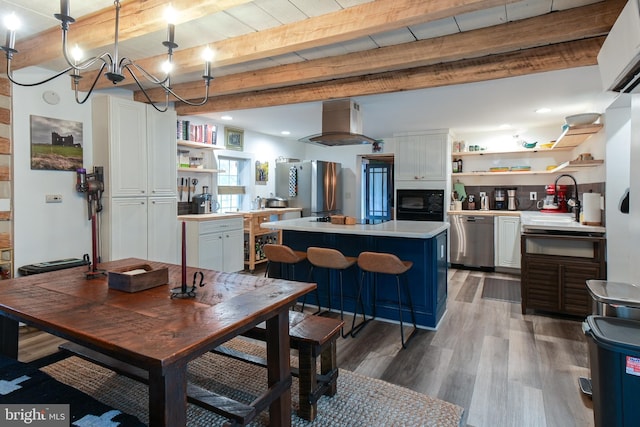 dining space featuring light wood-type flooring, a notable chandelier, and beam ceiling