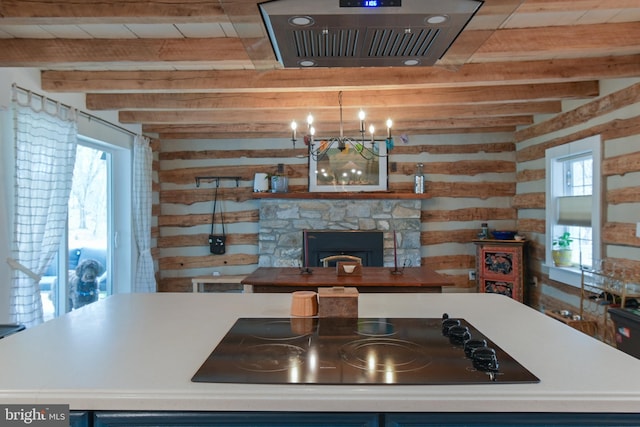 kitchen featuring visible vents, black electric stovetop, beam ceiling, and a wealth of natural light