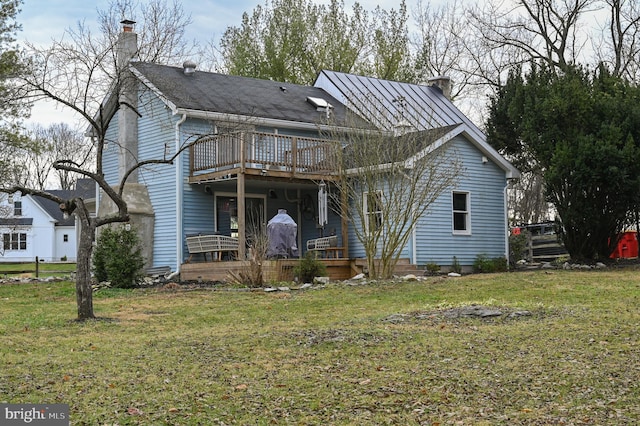 view of front facade featuring a deck, a chimney, and a front lawn