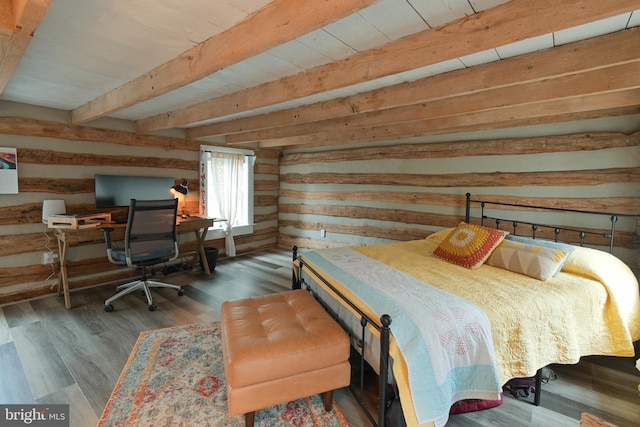 bedroom with wood walls, beamed ceiling, and wood finished floors