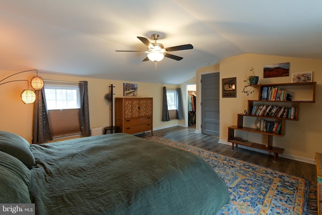 bedroom with baseboards, vaulted ceiling, and wood finished floors