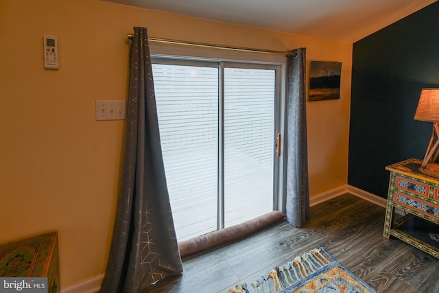 interior space with wood finished floors and baseboards