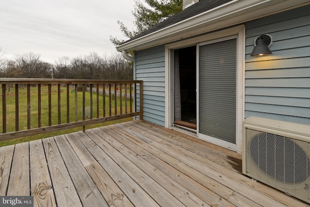 deck featuring ac unit and a lawn