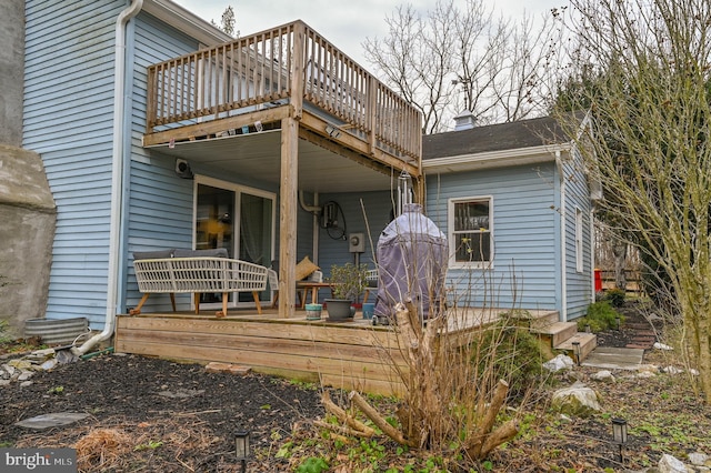 rear view of house featuring a wooden deck