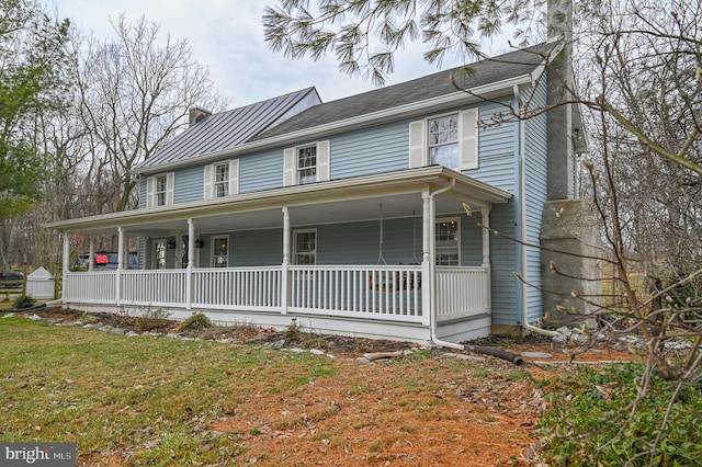 farmhouse-style home featuring a porch and a chimney