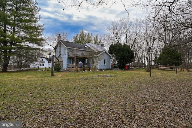 exterior space with a chimney, fence, a deck, and a yard