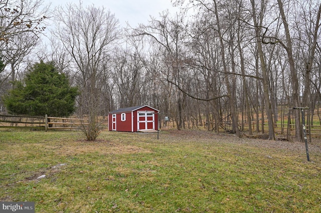 view of yard with a storage shed, fence, and an outdoor structure