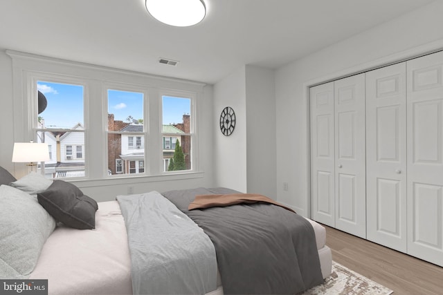 bedroom with light wood-type flooring and a closet