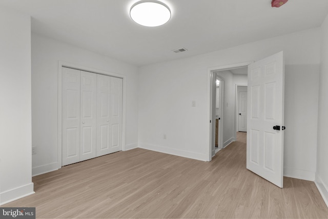 unfurnished bedroom featuring a closet and light hardwood / wood-style flooring