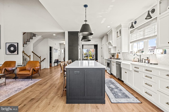 kitchen with pendant lighting, a center island, white cabinets, and stainless steel appliances