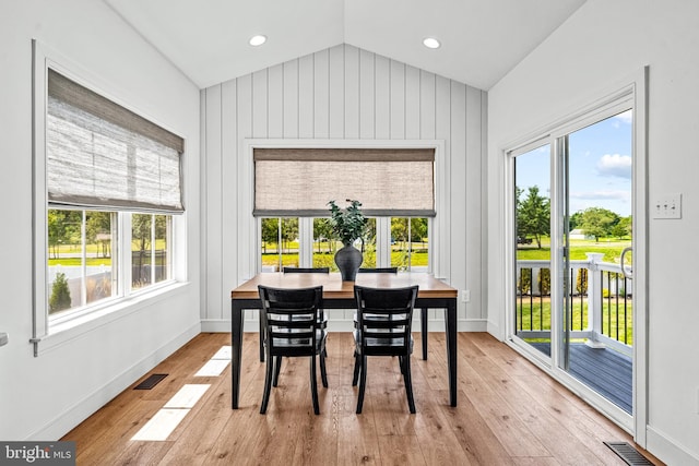 dining room with light hardwood / wood-style flooring and lofted ceiling