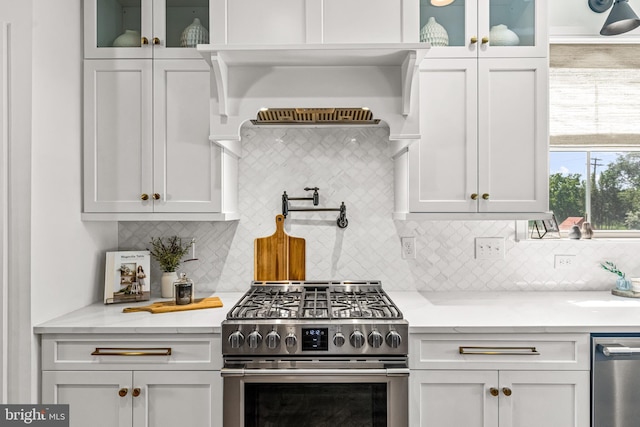 kitchen featuring decorative backsplash, white cabinetry, and appliances with stainless steel finishes