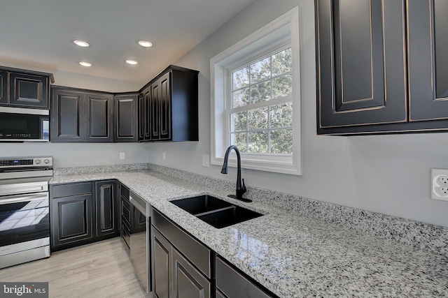 kitchen with light stone countertops, stainless steel appliances, and sink