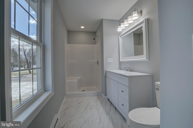 bathroom featuring vanity, toilet, walk in shower, and a wealth of natural light