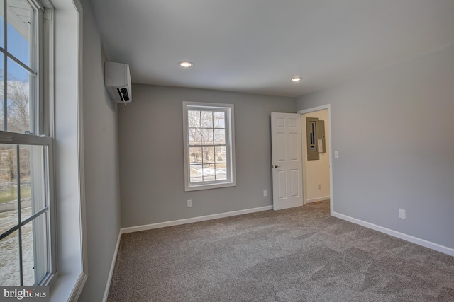 unfurnished room with carpet flooring, electric panel, and a wall unit AC