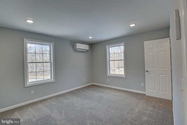 carpeted spare room featuring a wall mounted AC and a healthy amount of sunlight