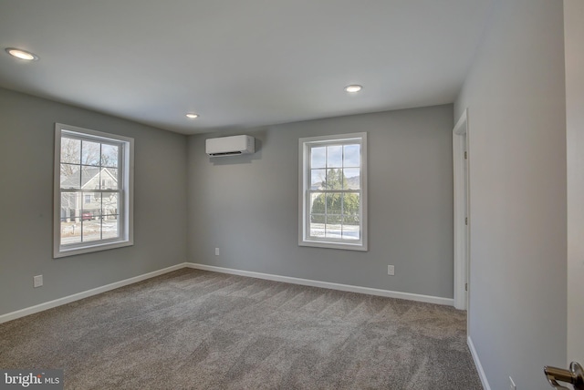 carpeted empty room with a wall mounted air conditioner and a wealth of natural light