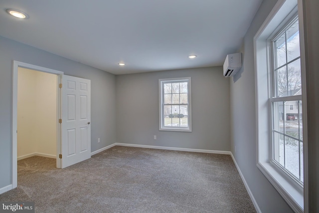 empty room with carpet floors and a wall mounted air conditioner